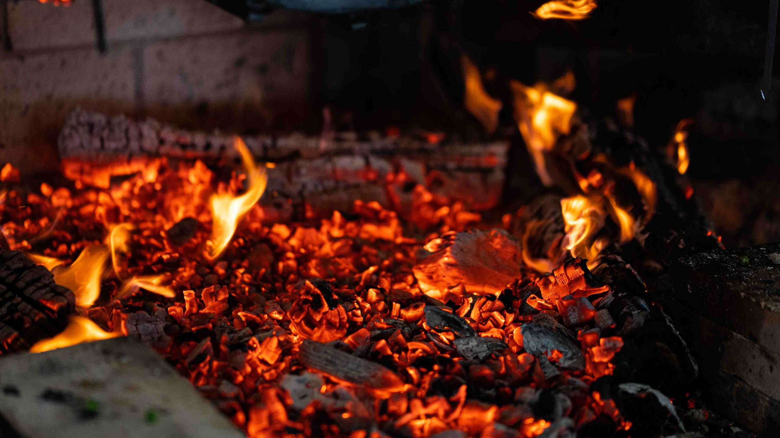 hot coals burning in the live fire cooking station